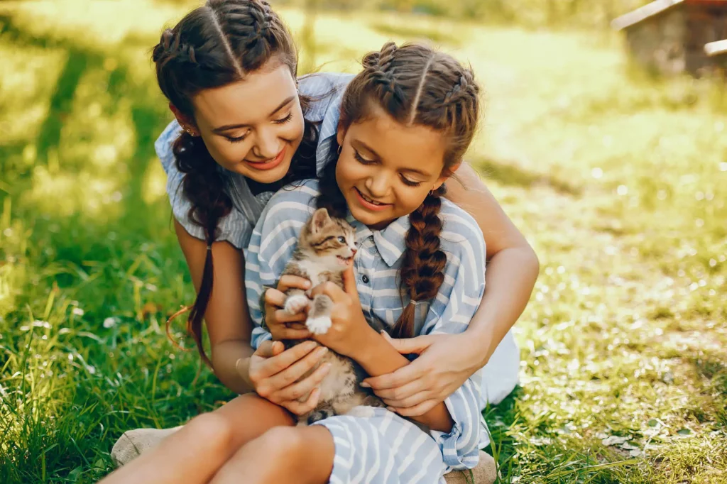 Duas meninas com gatinho de estimação.