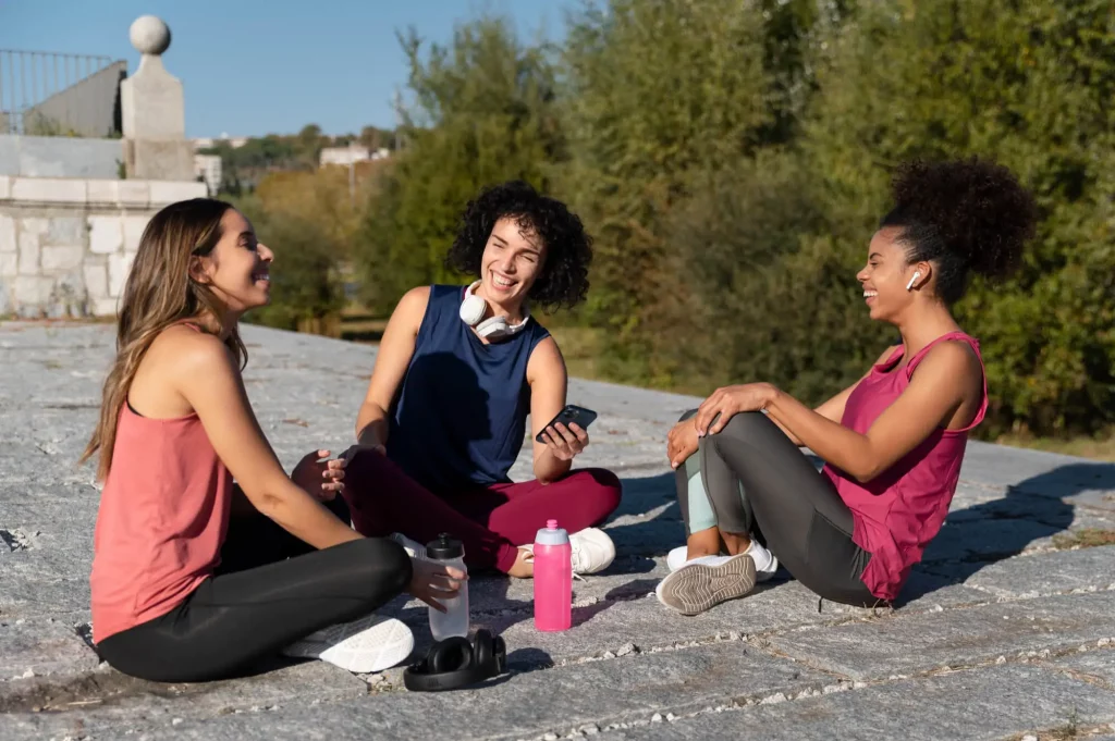 Grupo de mulheres conversando após praticar exercícios físicos